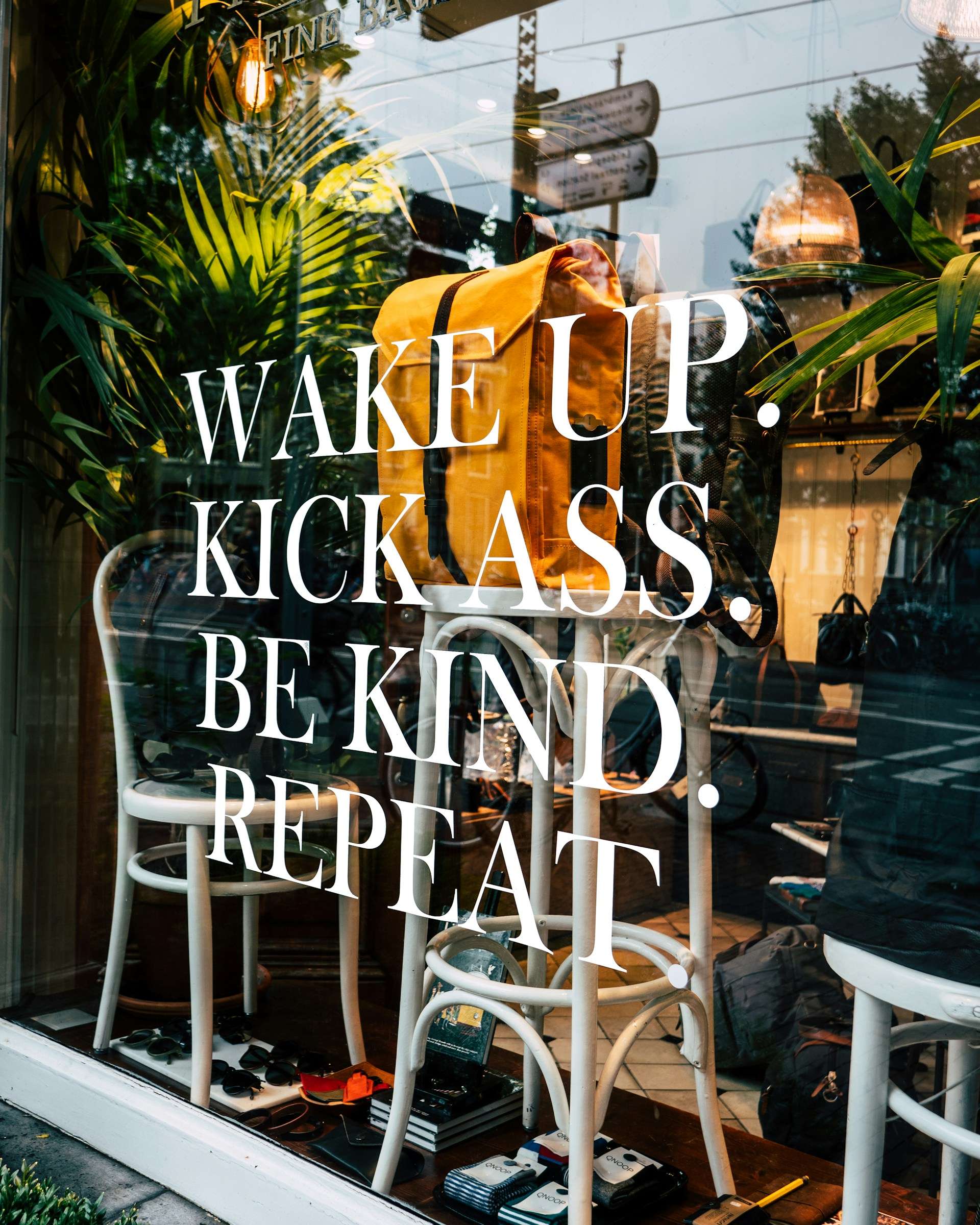 Inspirational storefront display with the phrase "Wake Up, Kick Ass, Be Kind, Repeat," reflecting the proactive and positive mindset needed for Administrative Assistant jobs at Towner Communications in Kansas City.