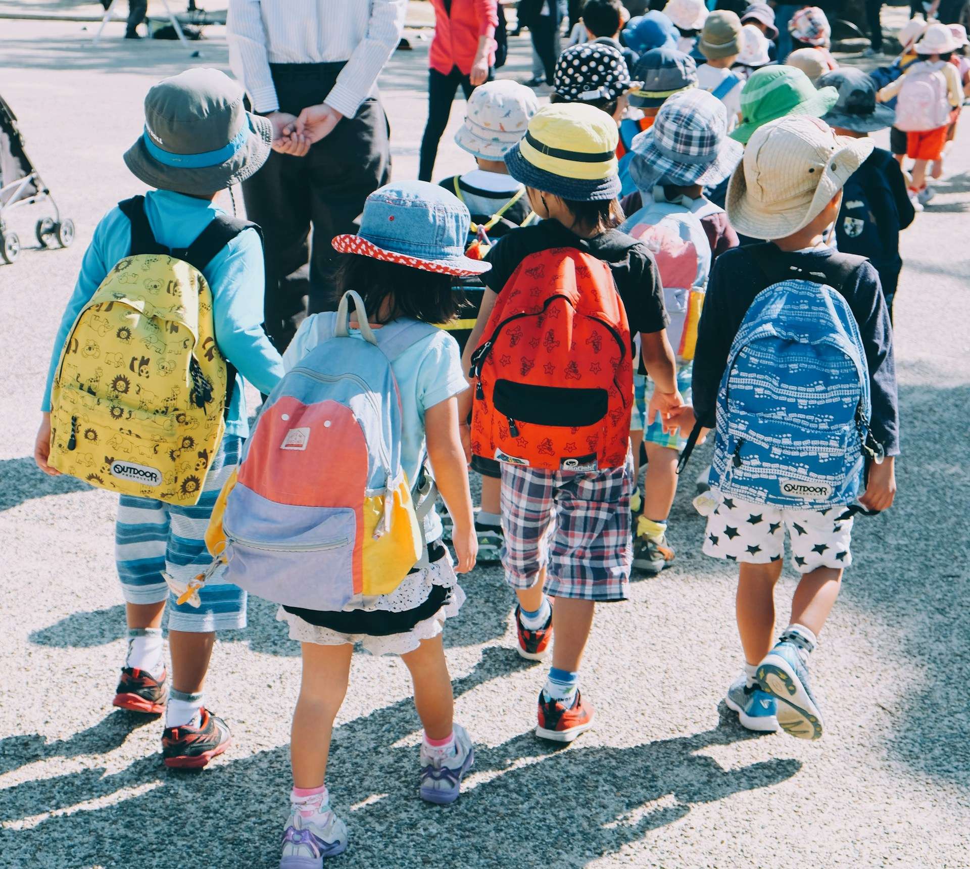Group of young children walking together with backpacks, symbolizing the need for school safety and emergency communication grants in Kansas and Missouri.