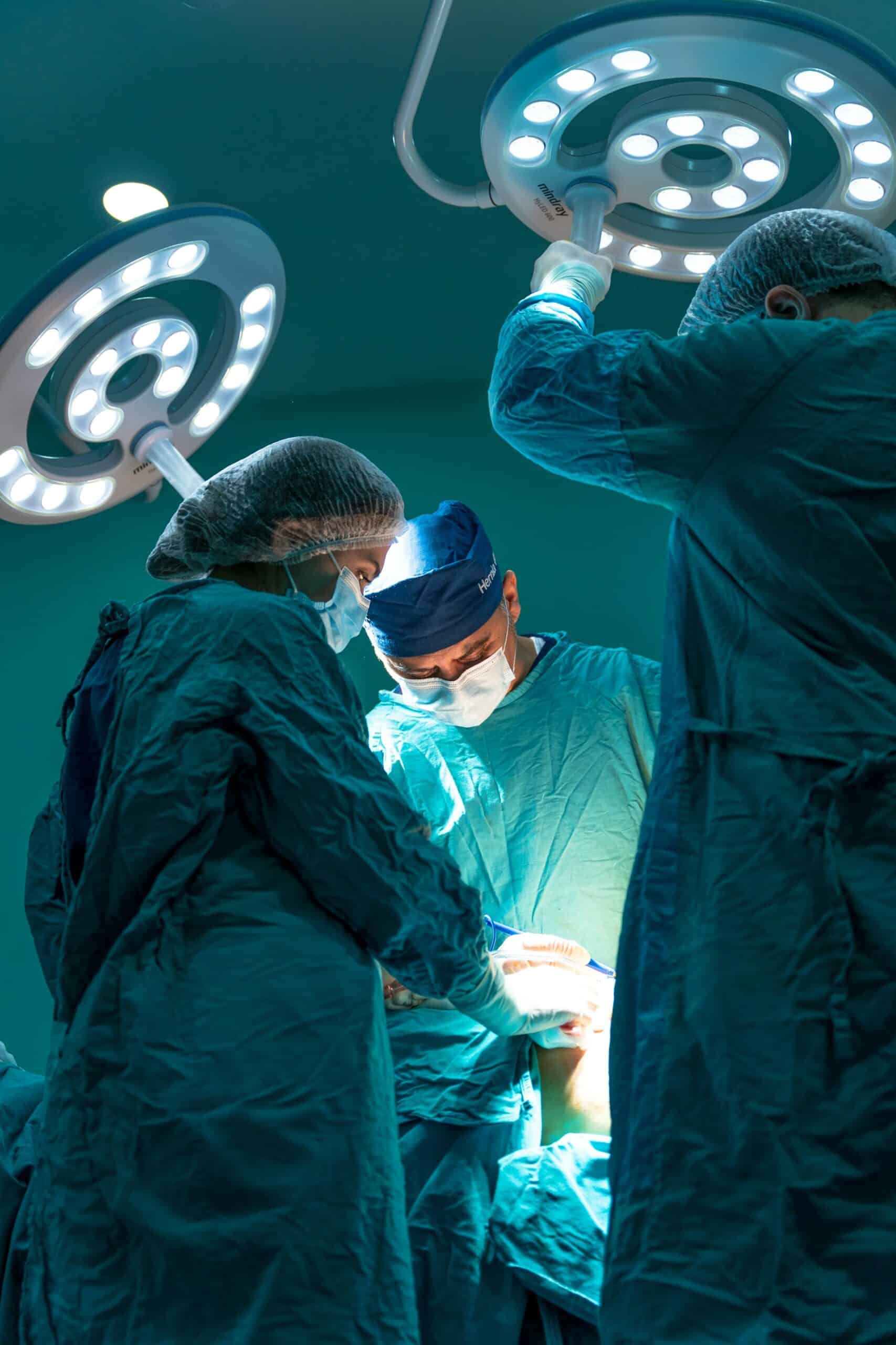 Surgical team working under bright lights in a hospital operating room, representing healthcare staff and patient safety systems provided by Towner Communications in Kansas City