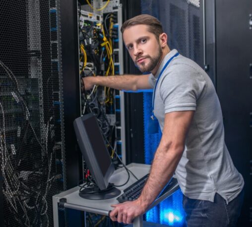 Mitel Field Technician configuring VoIP and UC equipment in a Kansas City server room for MiVoice Business and MiCollab deployment.