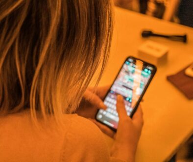 Person using smartphone to send business text messages, illustrating business texting best practices for compliance and engagement