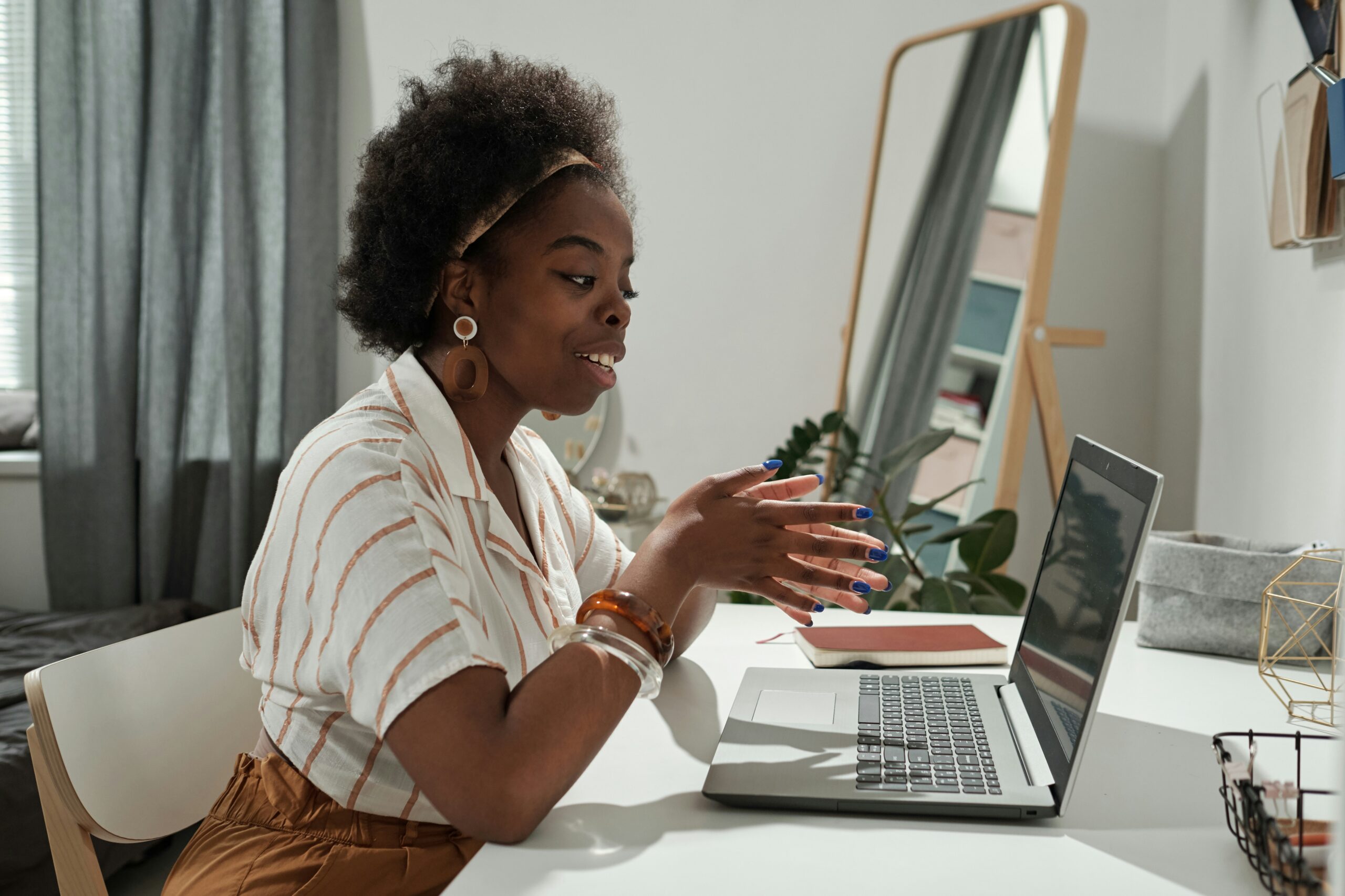 A business professional on a video call using Microsoft Teams Phone on a laptop in a home office setting